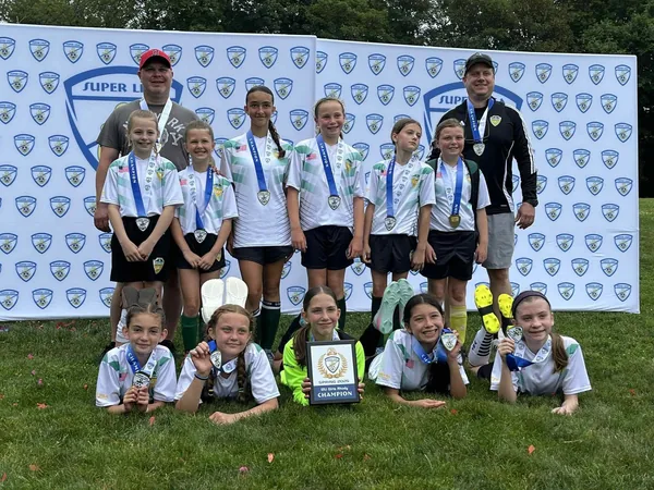 An NSYSA competitive team with their medals and championship plaque at a RI Superliga event