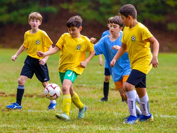 Four young NSYSA players chase the ball during a recreational game